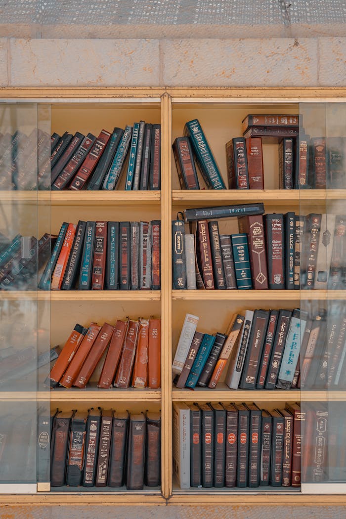 gallery-4 Glass-fronted bookshelf in Jerusalem displaying vintage books with leather covers.